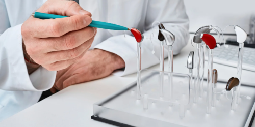 Audiologist showing off different hearing aid options